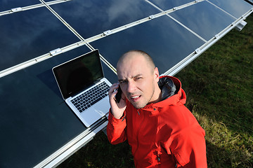 Image showing engineer using laptop at solar panels plant field