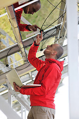 Image showing engineer using laptop at solar panels plant field