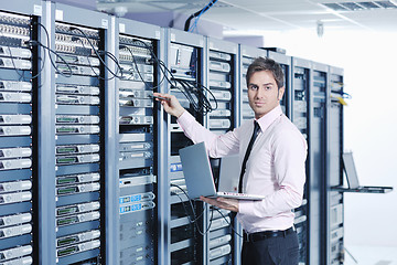 Image showing businessman with laptop in network server room