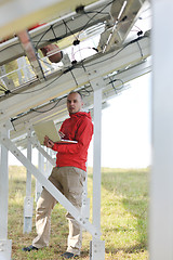 Image showing engineer using laptop at solar panels plant field