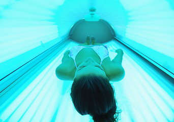 Image showing Beautiful young woman tanning in solarium