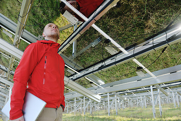 Image showing engineer using laptop at solar panels plant field