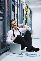 Image showing businessman with laptop in network server room