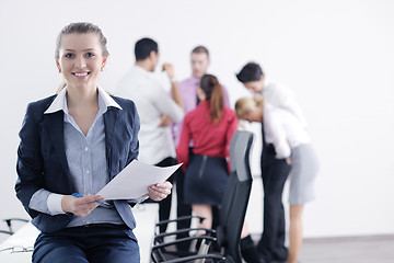 Image showing business woman standing with her staff in background