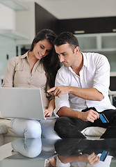 Image showing joyful couple relax and work on laptop computer at modern home