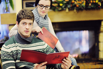 Image showing Young romantic couple sitting and relaxing in front of fireplace