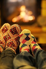 Image showing Young romantic couple sitting on sofa in front of fireplace at h