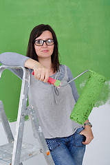 Image showing happy smiling woman painting interior of house