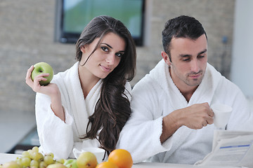 Image showing Happy couple reading the newspaper in the kitchen at breakfast