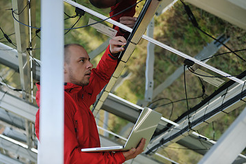 Image showing engineer using laptop at solar panels plant field