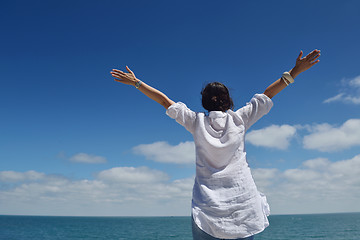 Image showing happy young woman with spreading arms to sky