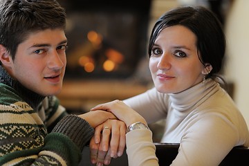 Image showing Young romantic couple relax on sofa in front of fireplace at hom