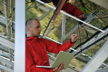 Image showing engineer using laptop at solar panels plant field