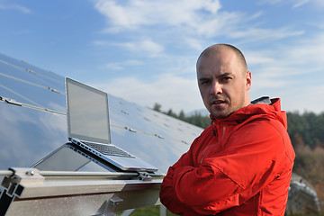 Image showing engineer using laptop at solar panels plant field