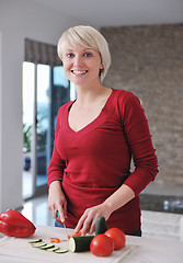 Image showing happy  beautiful blonde  woman prepare food in  the kitchen