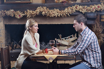 Image showing Young romantic couple sitting and relaxing in front of fireplace