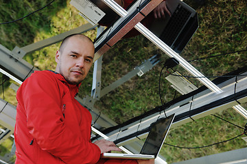 Image showing engineer using laptop at solar panels plant field