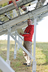 Image showing engineer using laptop at solar panels plant field