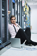 Image showing businessman with laptop in network server room