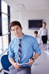 Image showing business man  on a meeting in offce with colleagues in backgroun