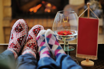 Image showing Young romantic couple sitting and relaxing in front of fireplace