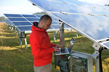 Image showing engineer using laptop at solar panels plant field