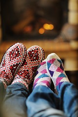 Image showing Young romantic couple sitting on sofa in front of fireplace at h