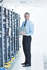 Image showing businessman with laptop in network server room