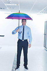 Image showing businessman hold umbrella in server room