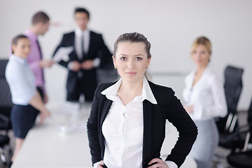 Image showing business woman standing with her staff in background