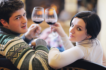 Image showing Young romantic couple sitting and relaxing in front of fireplace