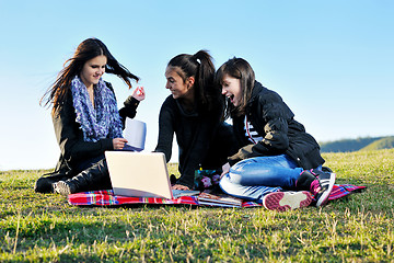 Image showing group of teens working on laptop outdoor