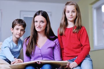 Image showing young mom play with their kids at home and reading book