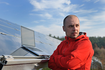 Image showing engineer using laptop at solar panels plant field