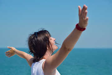 Image showing happy young woman with spreading arms to sky