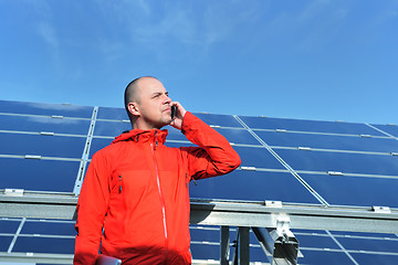 Image showing engineer using laptop at solar panels plant field