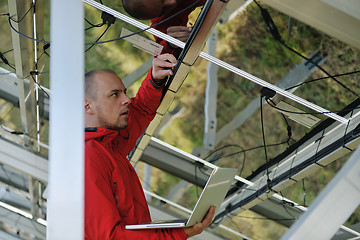 Image showing engineer using laptop at solar panels plant field