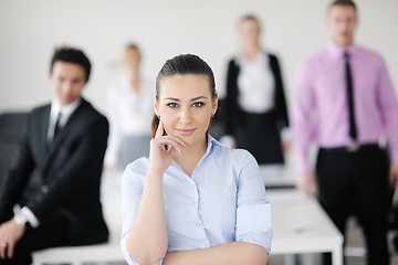 Image showing business woman standing with her staff in background