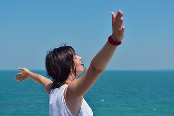 Image showing happy young woman with spreading arms to sky