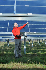 Image showing engineer using laptop at solar panels plant field