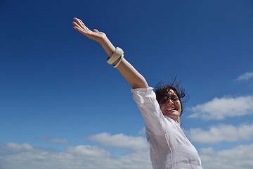 Image showing happy young woman with spreading arms to sky