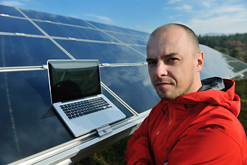 Image showing engineer using laptop at solar panels plant field