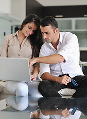 Image showing joyful couple relax and work on laptop computer at modern home