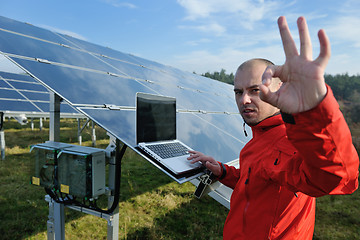 Image showing engineer using laptop at solar panels plant field