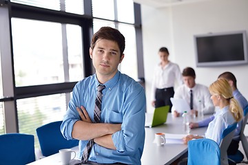 Image showing business man  on a meeting in offce with colleagues in backgroun