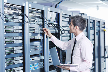 Image showing businessman with laptop in network server room