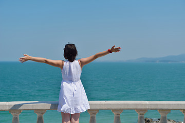 Image showing happy young woman with spreading arms to sky