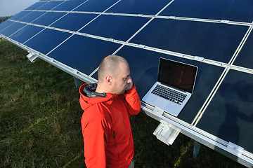 Image showing engineer using laptop at solar panels plant field