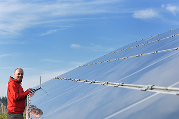 Image showing engineer using laptop at solar panels plant field