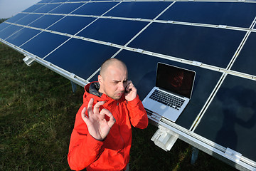 Image showing engineer using laptop at solar panels plant field